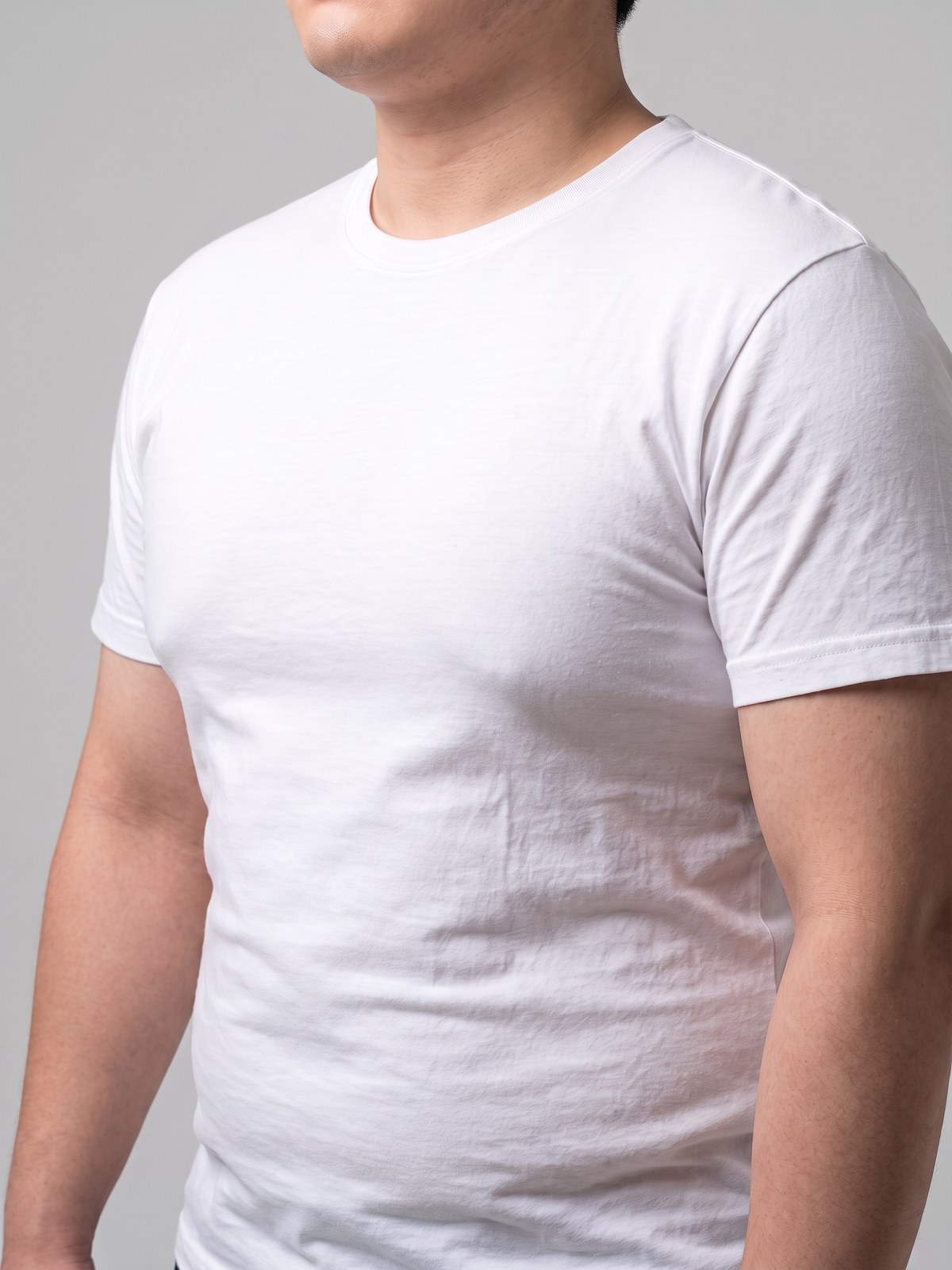 الجزء العلوي من جسم رجل يرتدي قميصًا أبيض ويظهر صدره بارزًا ومستديرًا
