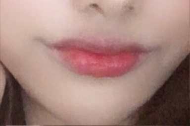 Close-up of lips with coral lip color and the jawline