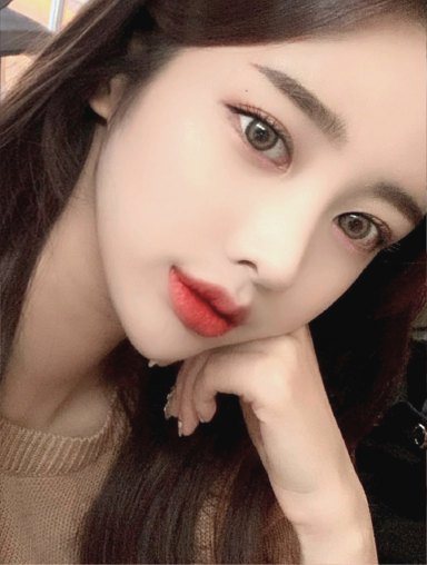 Selfie of a woman resting her chin on the back of her hand, facing forward