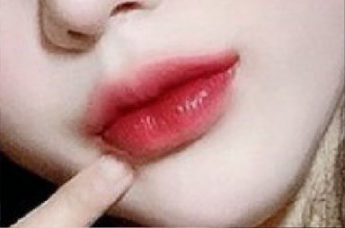 Close-up of lips with a finger touching the lower lip