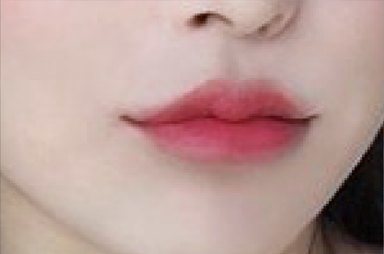 Close-up of lips with red lip color and the sides of the nose