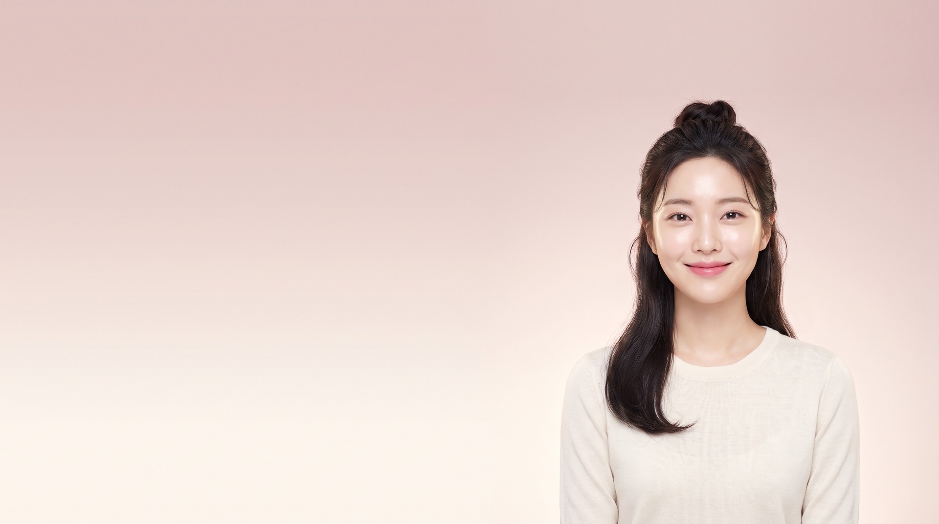 Female model smiling with raised lip corners in front of a background that fades from dusty rose to warm cream