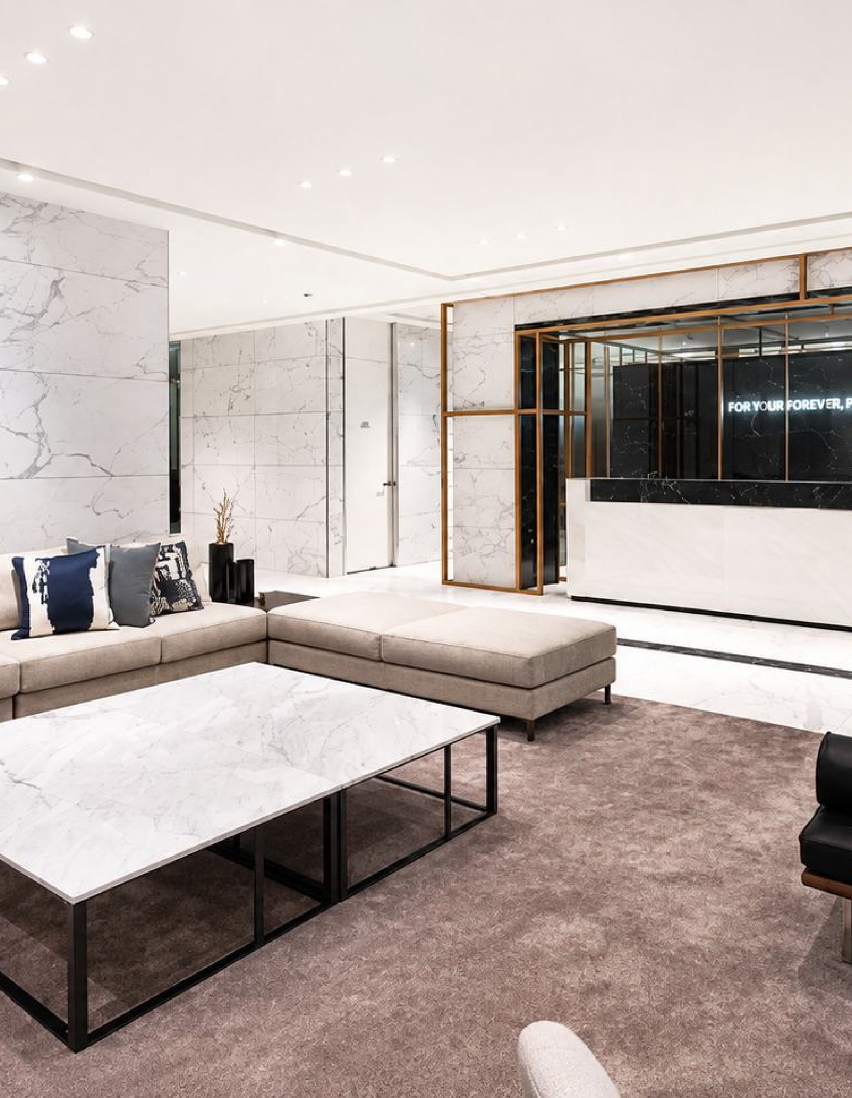 Area tunggu konsultasi Klinik Bedah Plastik Four Seasons — lounge dengan dinding marmer dan sofa krem