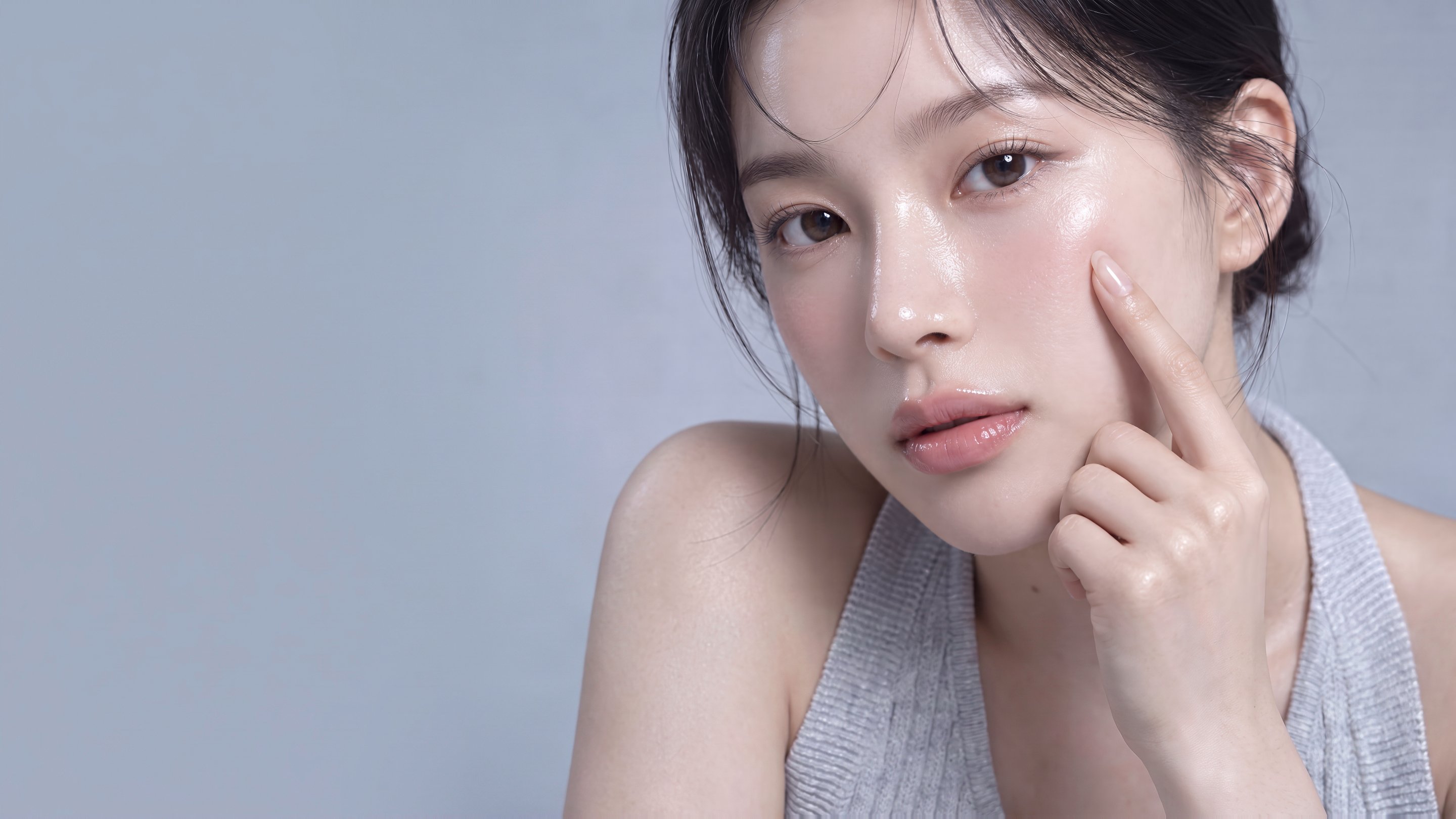 Close-up of a female model touching her cheek with a finger — Ultherapy and Thermage lifting