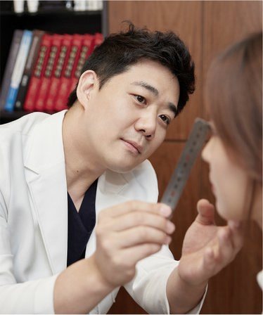 계측자를 들고 환자의 옆모습 코를 살펴보는 제갈정재 대표원장