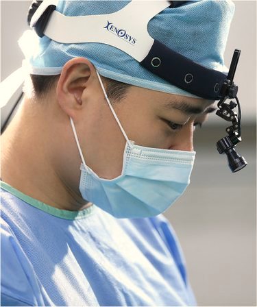 수술복과 수술용 헤드라이트를 착용하고 수술을 준비하는 의료진