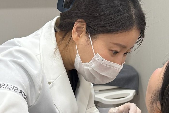 Medical staff performing a skin procedure on a patient in the treatment room