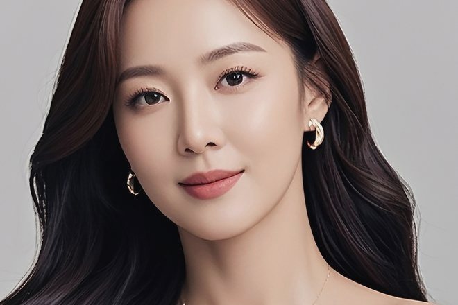 Close-up wajah model wanita dengan kepala sedikit menoleh di depan latar abu-abu