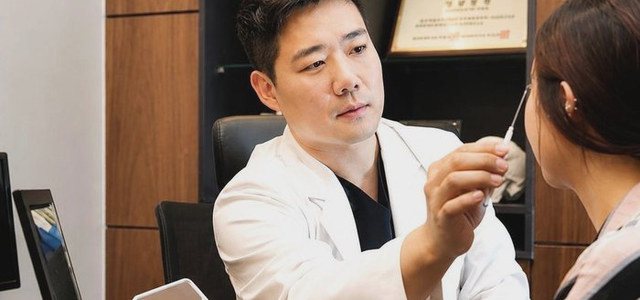 手持手鏡向患者說明恢復狀況與護理方法的院長